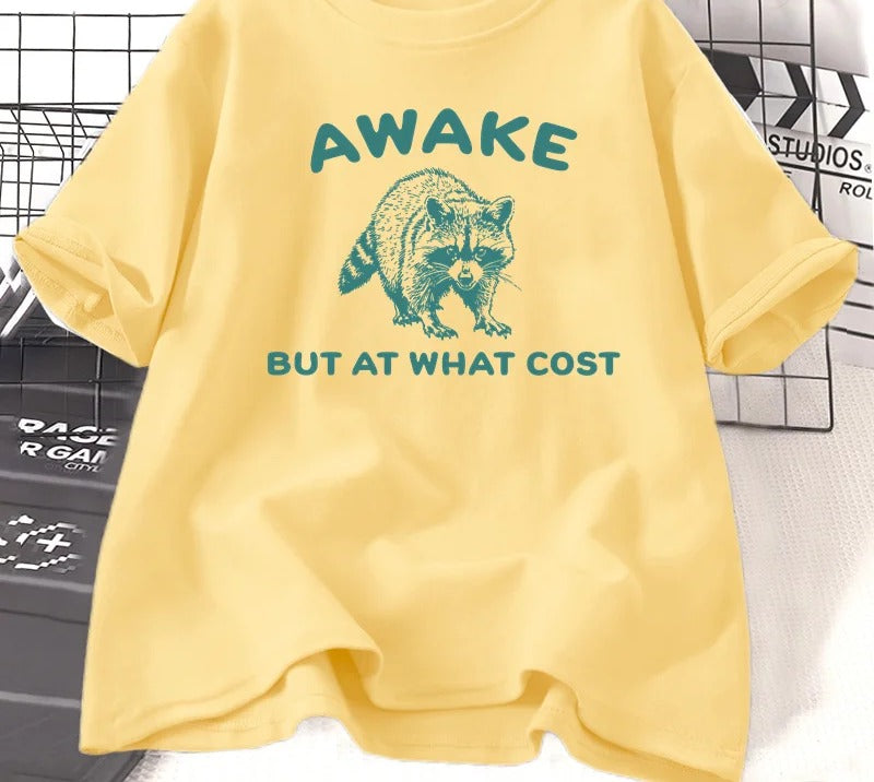 Yellow cotton tee printed with a teal engraved raccoon and the words awake but at what cost