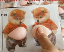 A hand squashing the soft belly of the shiba pair, about 11 cm by 7 cm