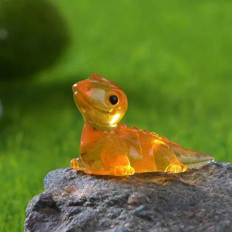 A translucent orange lizard perched on a rock