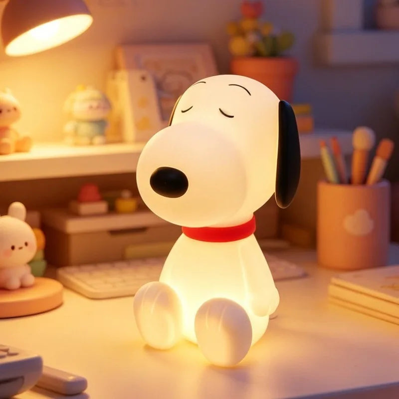 The lit cartoon dog lamp on a tidy desk beside a pen pot and a keyboard, showing its size against everyday objects