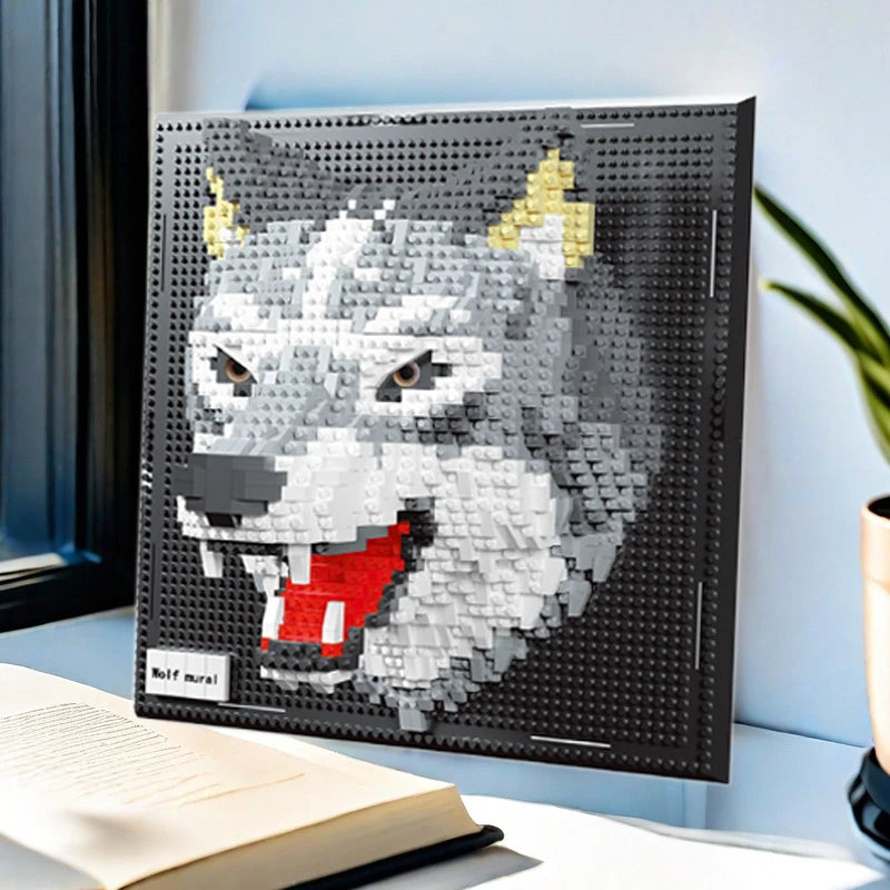 Brick built grey wolf head with red tongue on a black studded panel, propped on a desk beside an open book