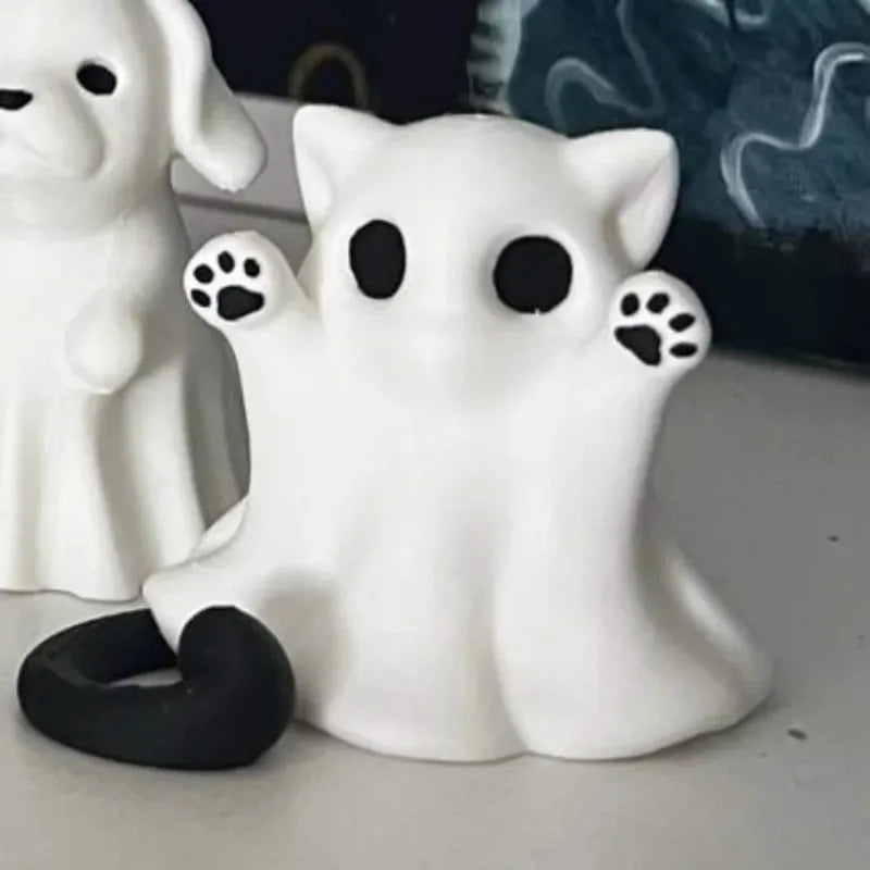 The ghost cat beside a separate ghost dog figure on a white surface