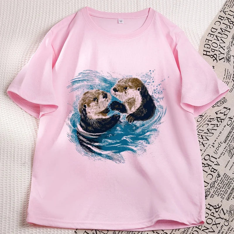 Pink sea otter tee laid flat, two otters printed on the chest
