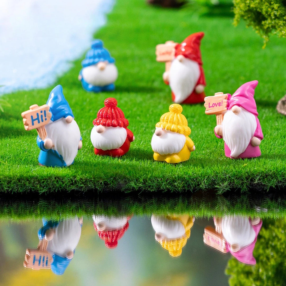 Gnomes standing at the edge of a painted pond with their reflections showing - the pond, grass and trees are staging only