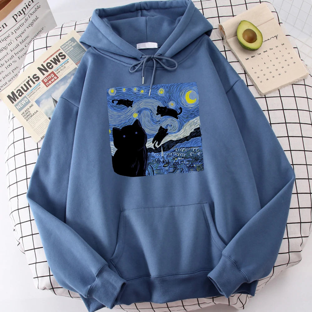 Haze blue fleece pullover hoodie with a large front print of a swirling starry night sky, a crescent moon and black cats over a village
