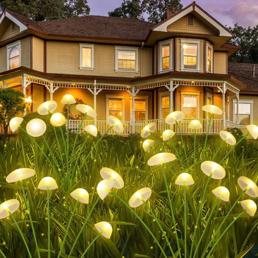 Warm white stakes massed along the front of a house at dusk