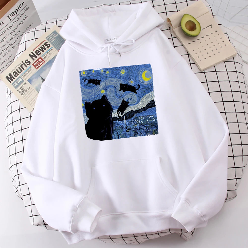 White fleece pullover hoodie with a large front print of a swirling starry night sky, a crescent moon and black cats over a village