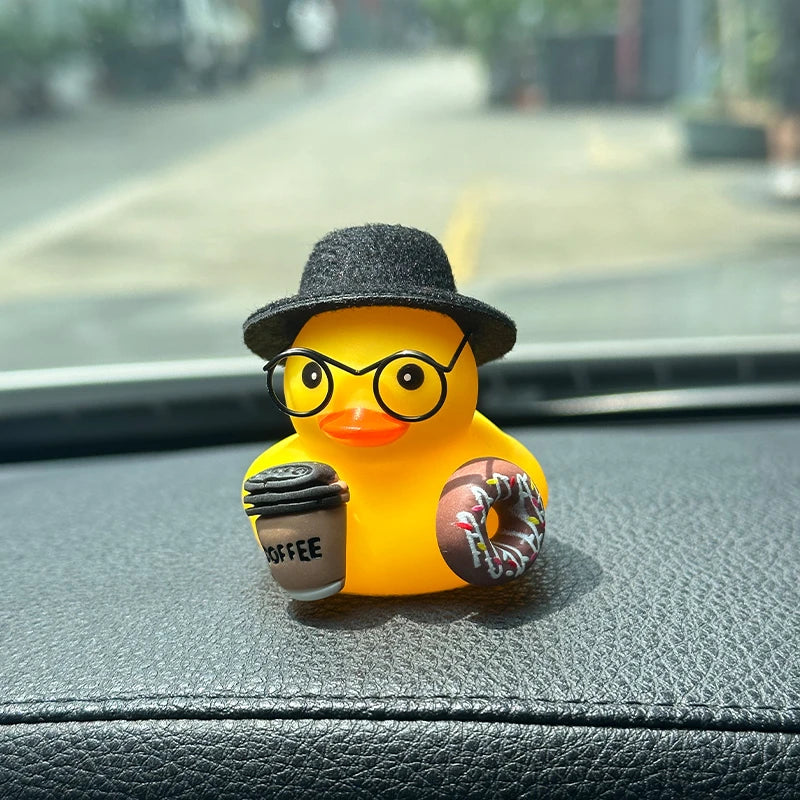 Black Hat: yellow rubber duck in a black felt hat and round glasses, holding a coffee cup and a pink donut