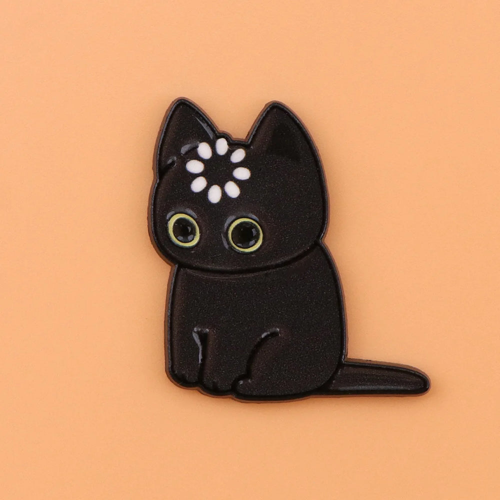 Solid black cat magnet with a ring of white dots on its head