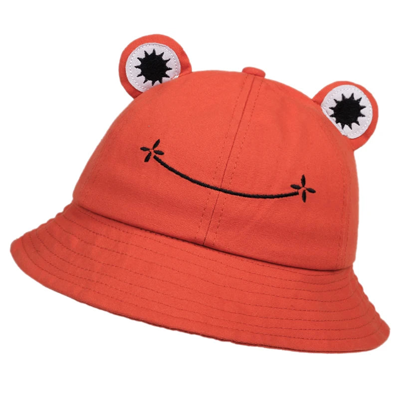 Orange cotton bucket hat with applique frog eyes and an embroidered smile