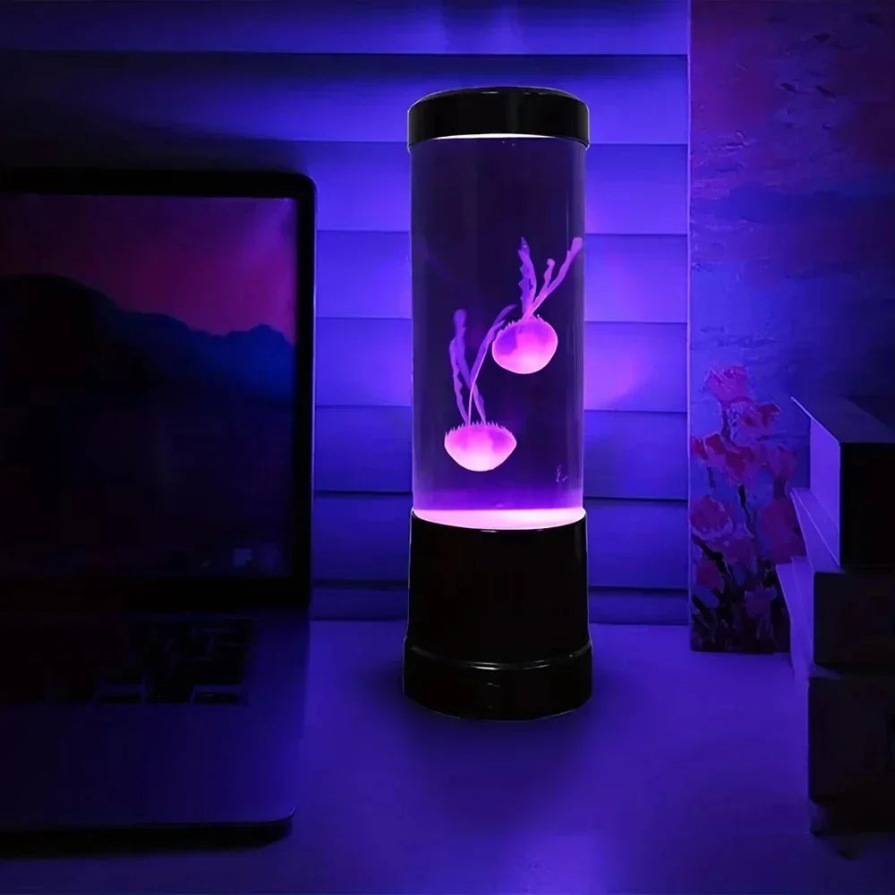Jellyfish lamp lit purple on a desk at night beside a laptop