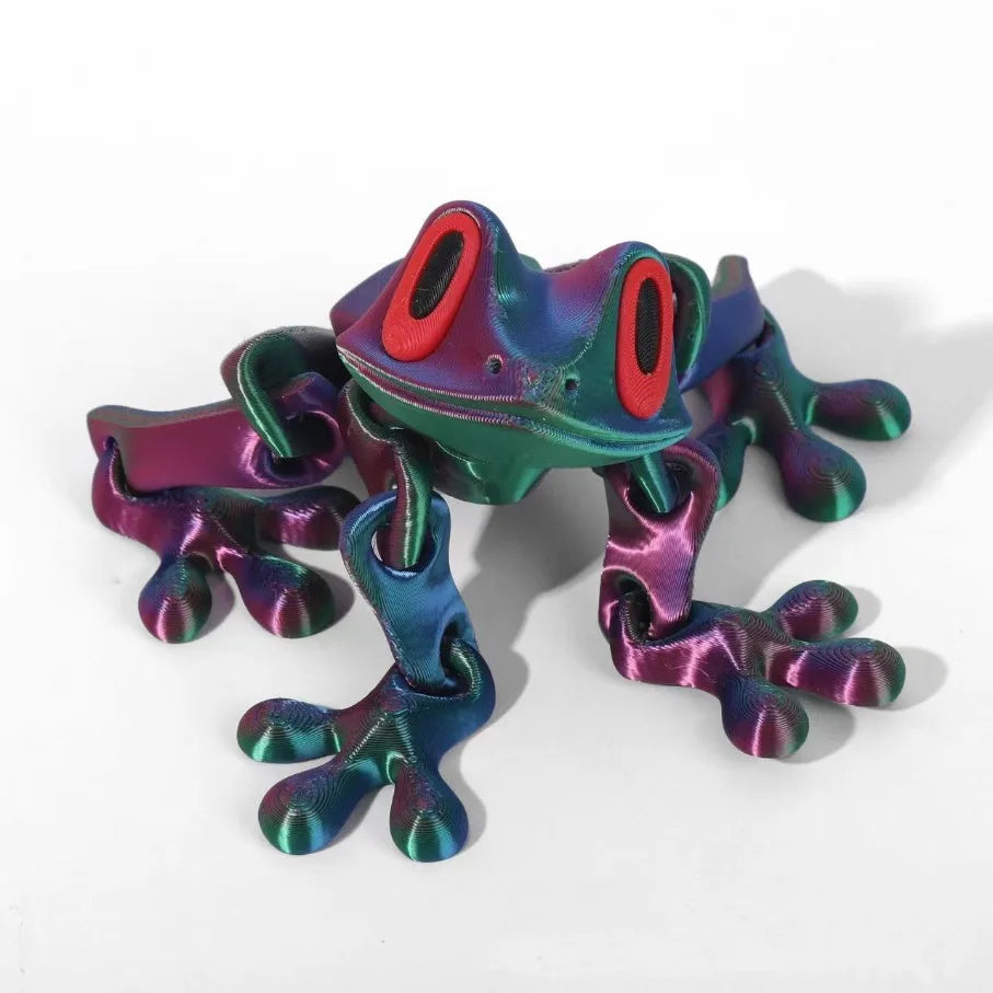 The purple-green frog lying flat on a white surface, toes spread