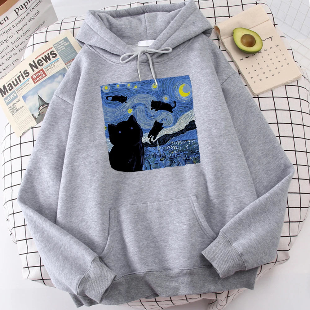 Grey fleece pullover hoodie with a large front print of a swirling starry night sky, a crescent moon and black cats over a village