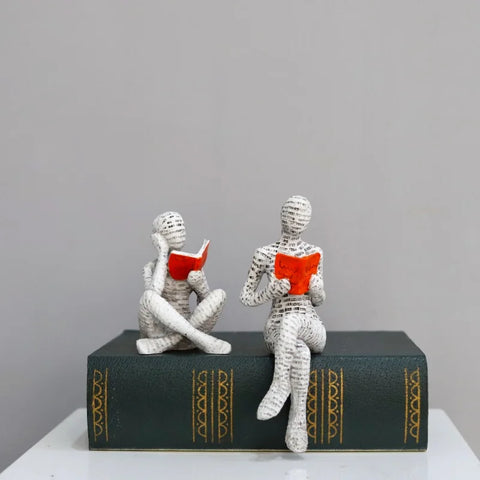 Both poses side by side on a hardback book, cross-legged and legs hanging