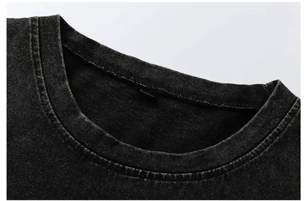 Close-up of the ribbed crew neck and shoulder seam on the washed dark fabric