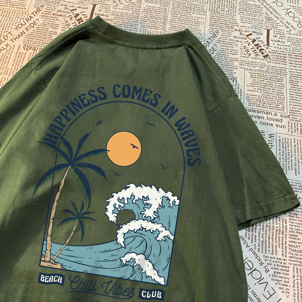 Dark green cotton tee with a large back print of a breaking wave, palm trees and a low sun, under the arched words Happiness Comes In Waves