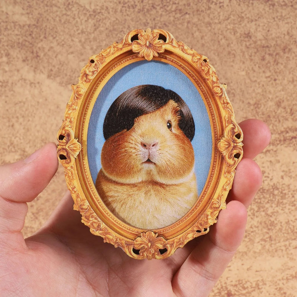 The guinea pig framed magnet held in a hand to show its size