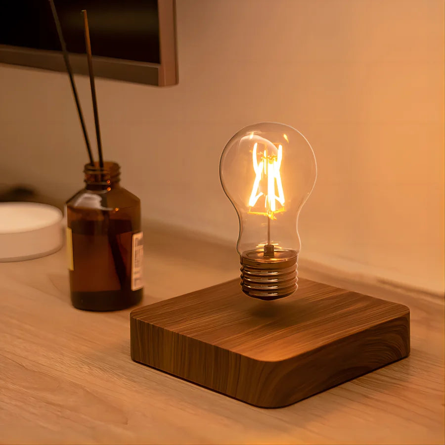 The square-base lamp lit beside a reed diffuser on a shelf