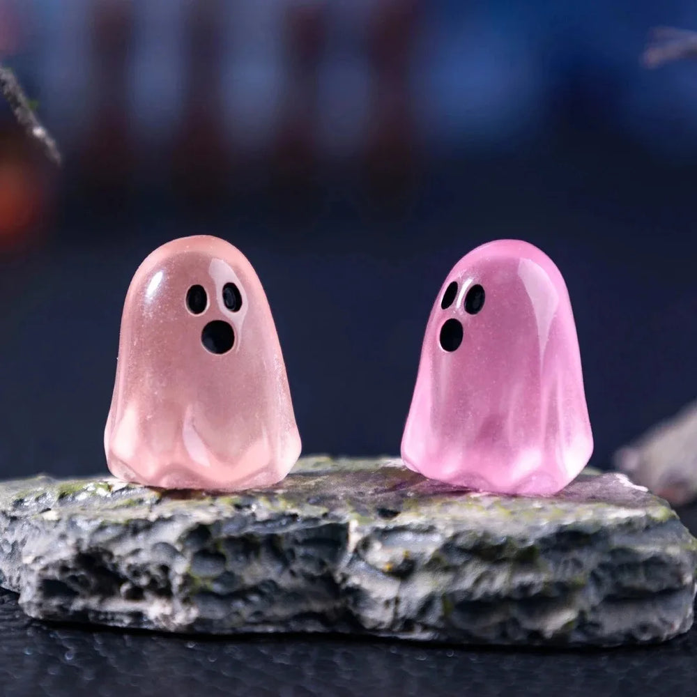 Two pink ghosts standing on a mossy miniature rock - the rock is not included