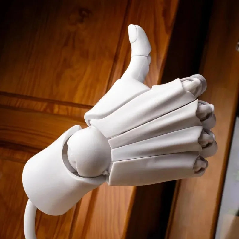 White poseable hand model giving a thumbs-up, photographed against a wooden door