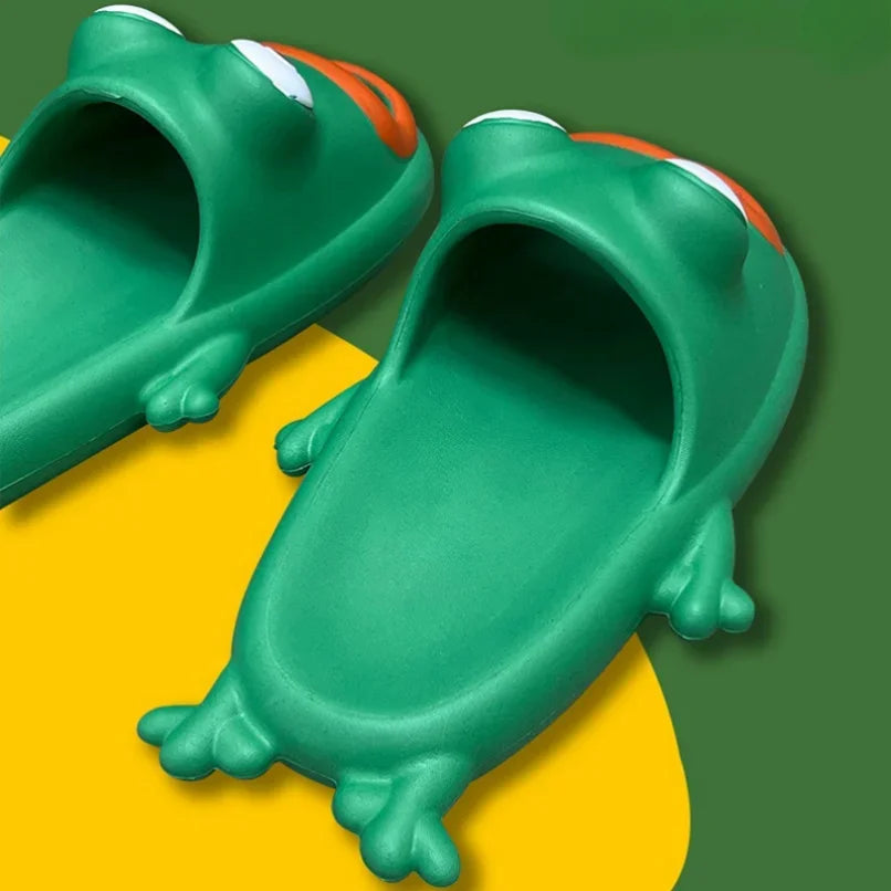 Pair of green cartoon frog slides with orange mouth openings and domed eyes