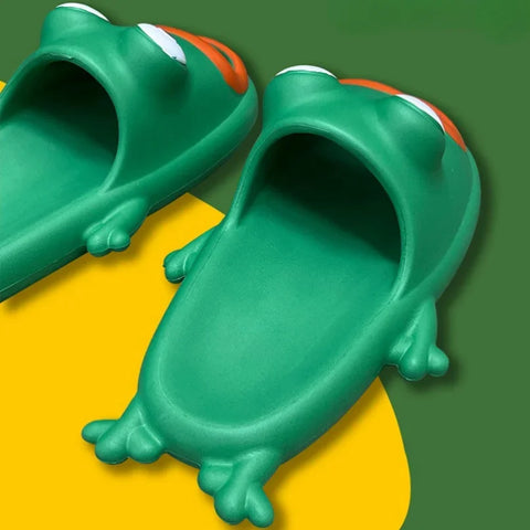 Pair of green cartoon frog slides with orange mouth openings and domed eyes