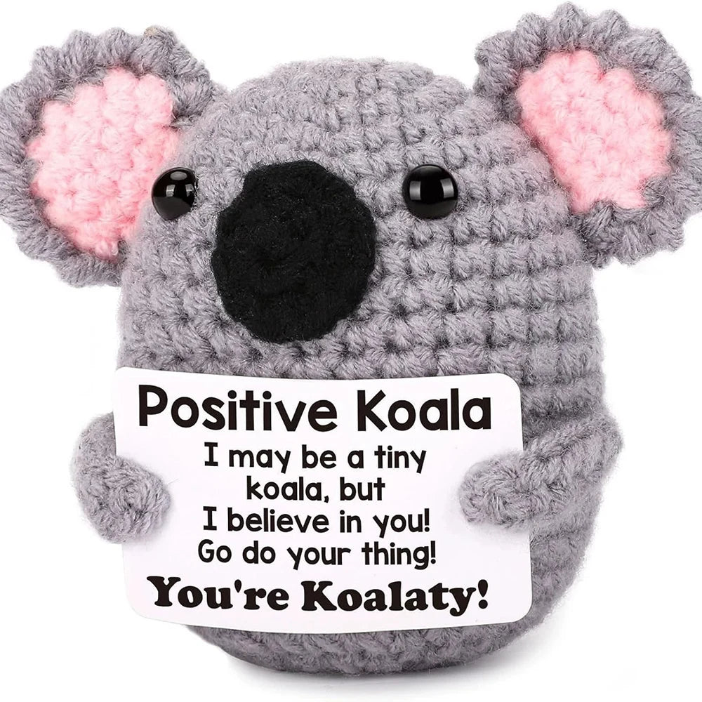 Crochet positive affirmation doll holding an encouragement card