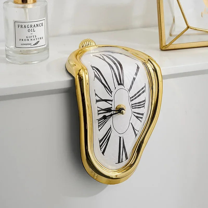 Gold melting clock draped over a shelf beside a fragrance bottle