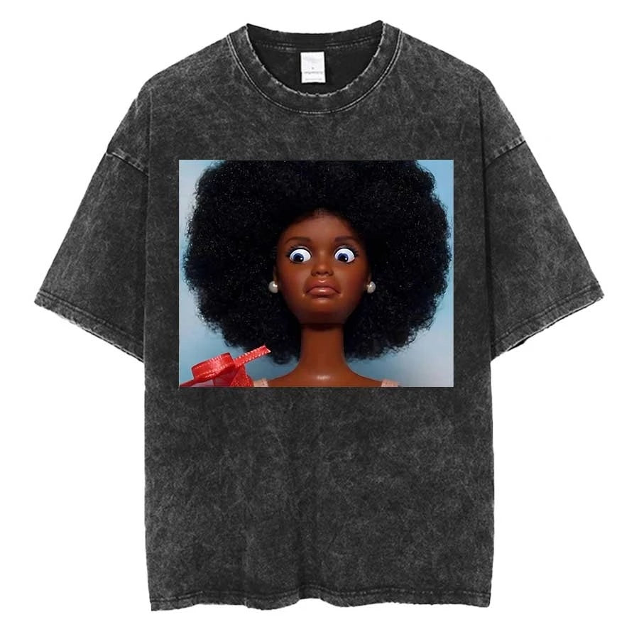 Washed charcoal oversized tee printed with a dark-skinned doll with a large afro and pearl earrings, wide eyed, red bow at the shoulder, pale blue background