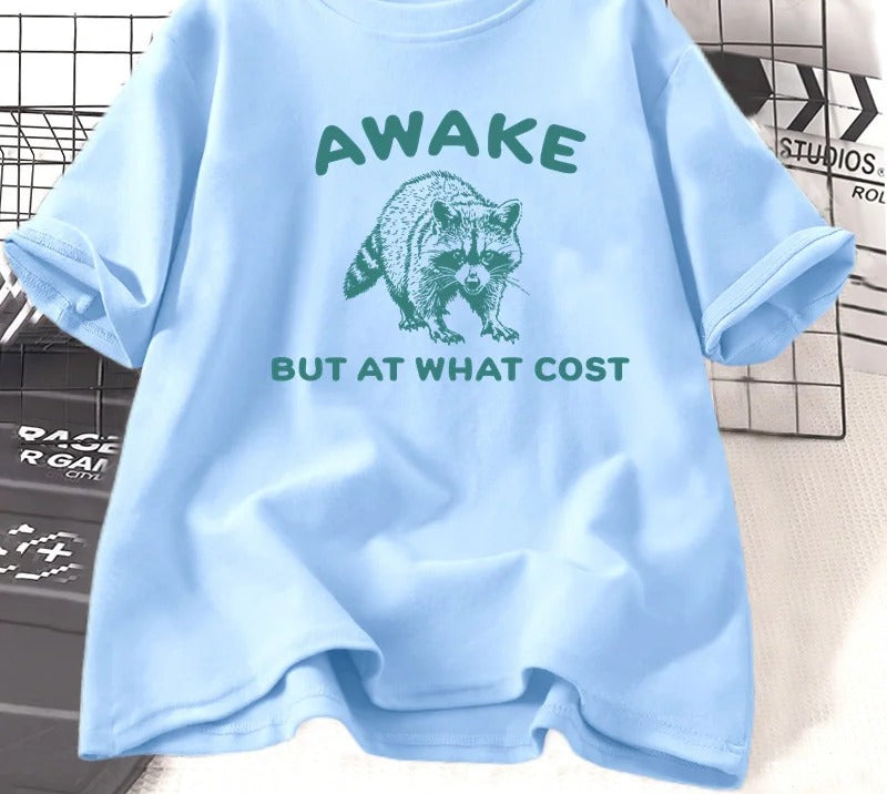 Sky blue cotton tee printed with a teal engraved raccoon and the words awake but at what cost